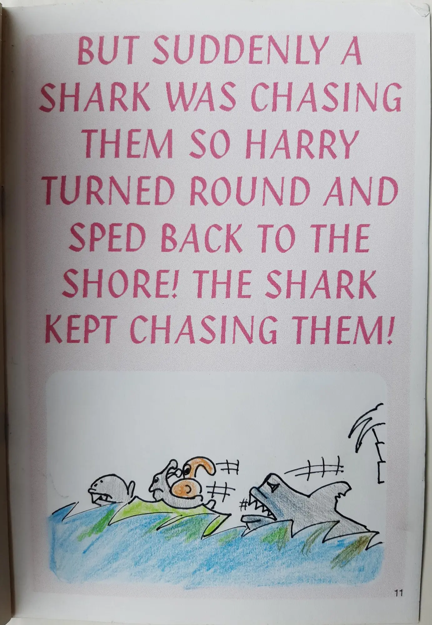 Page 11 of 16 of Alex’s school book. But suddenly a shark was chasing them so Harry turned round and sped back to the shore! The shark kept chasing them! Drawing: The shark chasing the leaf boat.